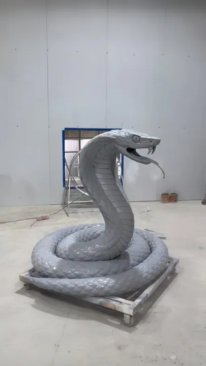 Coiled cobra sculpture on a pallet in the fabrication shop