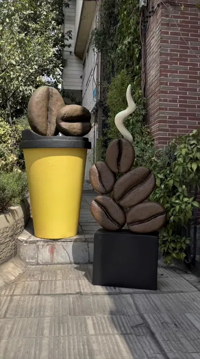 Giant coffee cup and coffee bean sculptures at a café entrance