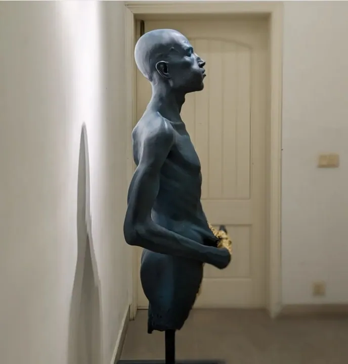Dark patinated figurative sculpture of a man looking upward