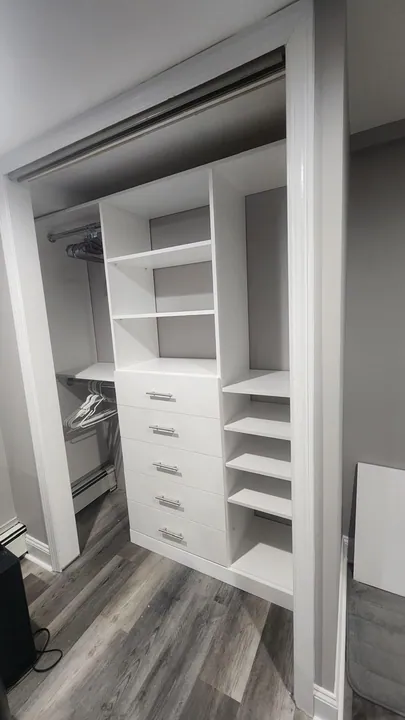 Custom white built-in closet with drawers and adjustable shelving