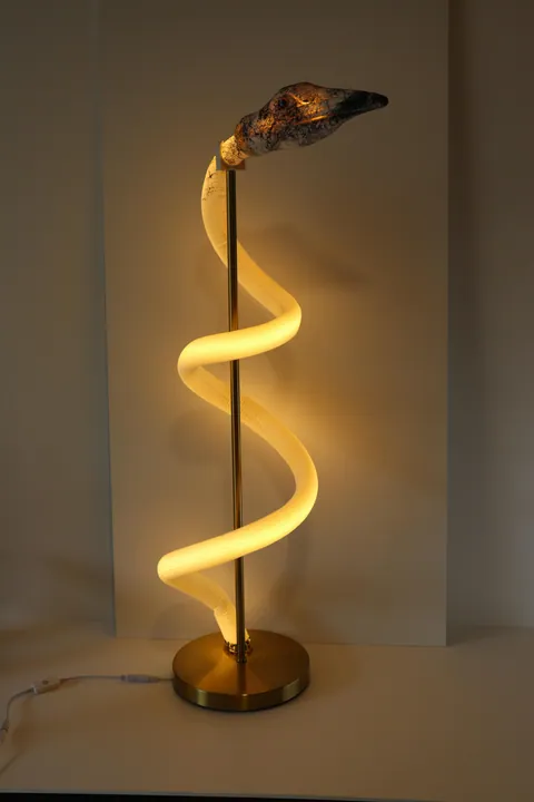 Spiral LED floor lamp with brass base glowing warm white